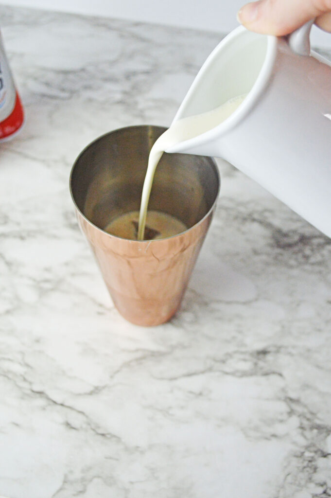 cream pouring into a cocktail shaker