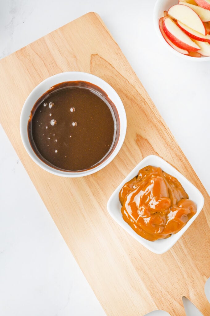 chocolate and caramel sauce in bowls on a serving board