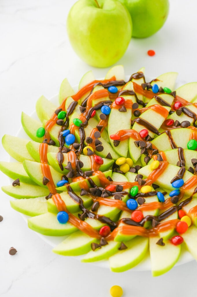 caramel apple nachos- granny smith apples fanned out, and drizzed with chocolate and caramel sauce, topped with mini chocolate chips & M&Ms