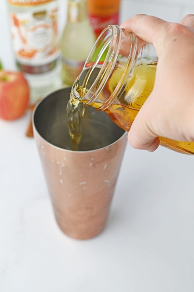 apple cider pouring into a shaker cup