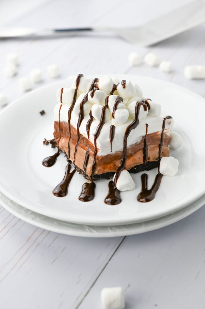 hot chocolate lasagna with layers of oreo crust, hot chocolate cheesecake, chocolate pudding, and marshmallow cool whip