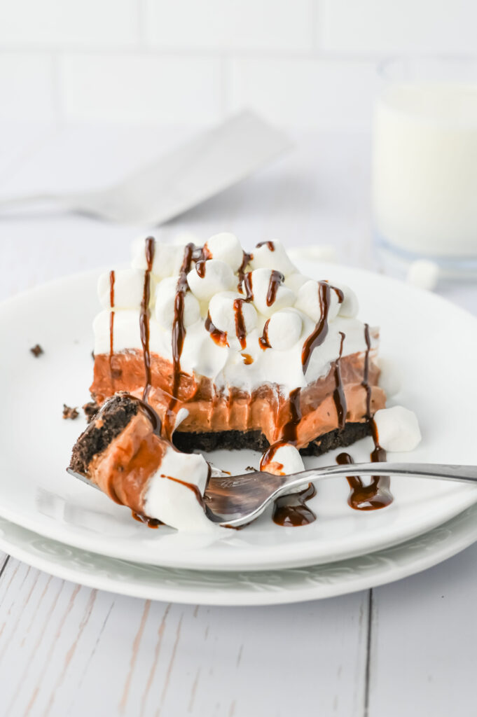 hot chocolate lasagna with layers of oreo crust, hot chocolate cheesecake, chocolate pudding, and marshmallow cool whip