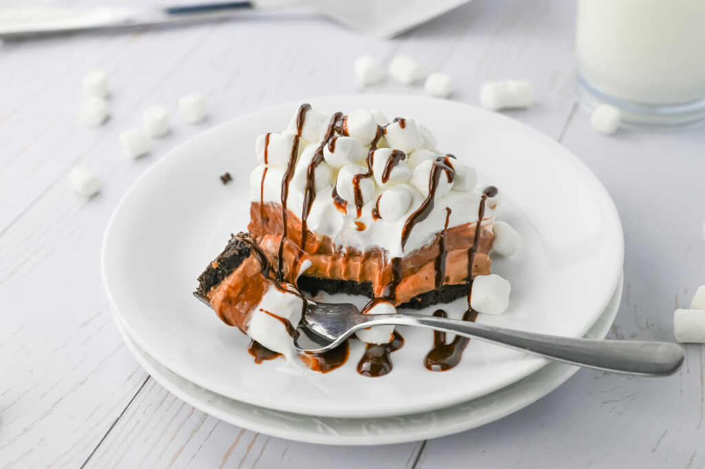 hot chocolate lasagna with layers of oreo crust, hot chocolate cheesecake, chocolate pudding, and marshmallow cool whip
