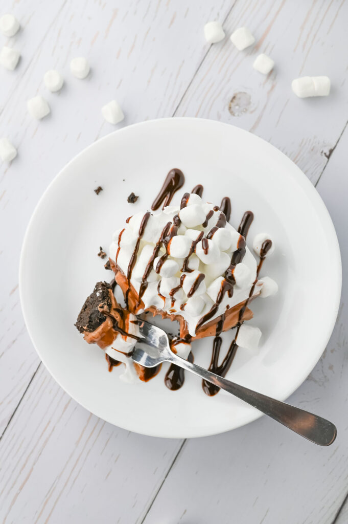 hot chocolate lasagna with layers of oreo crust, hot chocolate cheesecake, chocolate pudding, and marshmallow cool whip
