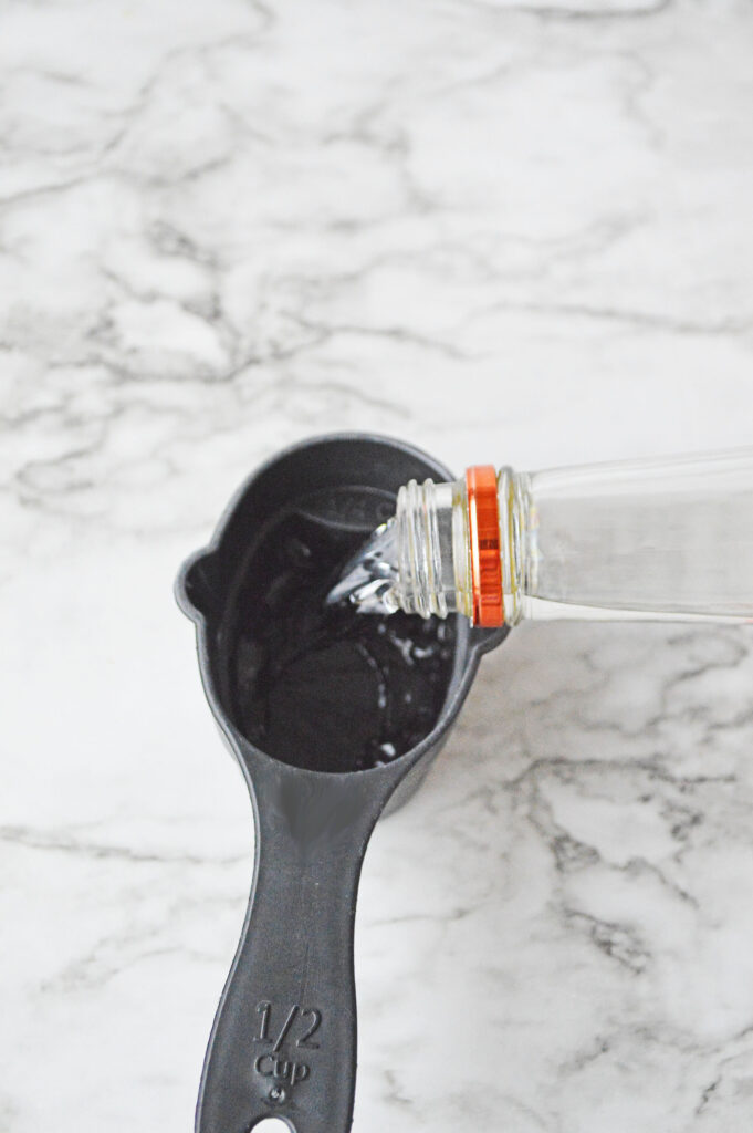 Pouring vodka into a measuring cup.