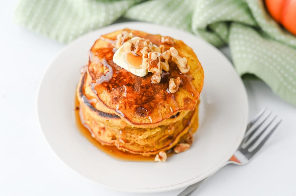 pumpkin pancakes with syrup and chopped nuts