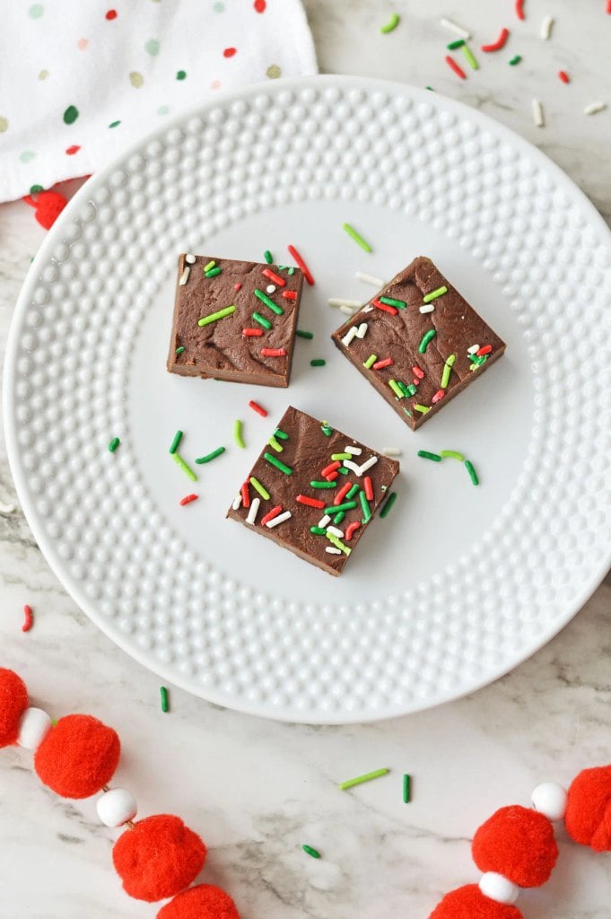 Homemade Christmas fudge squares topped with festive red and green sprinkles.