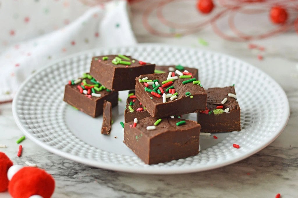 Easy four-ingredient chocolate Christmas fudge cut into bite-sized squares.