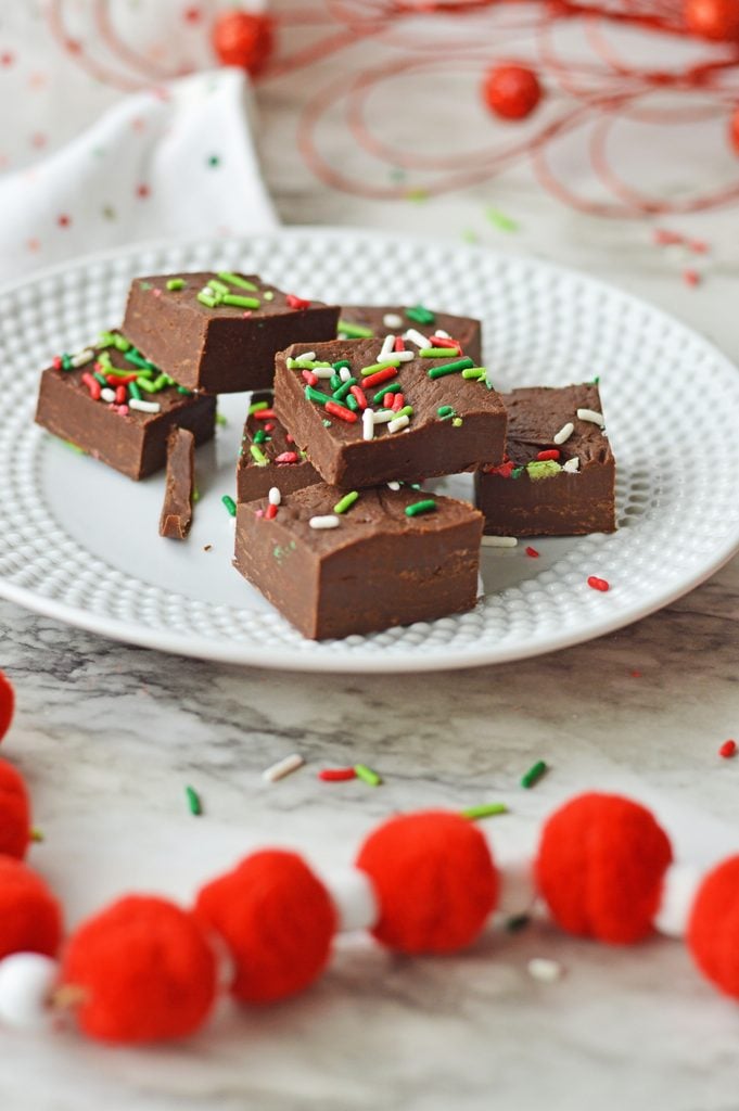 Close-up of creamy chocolate Christmas fudge decorated with holiday sprinkles.