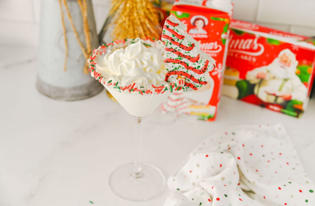 Sweet and creamy Christmas martini garnished with a Little Debbie Christmas Tree Cake.