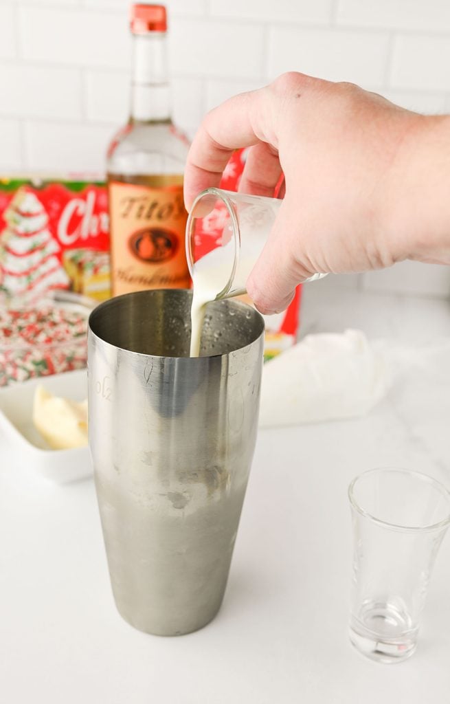 Pouring cream into the cocktail shaker.