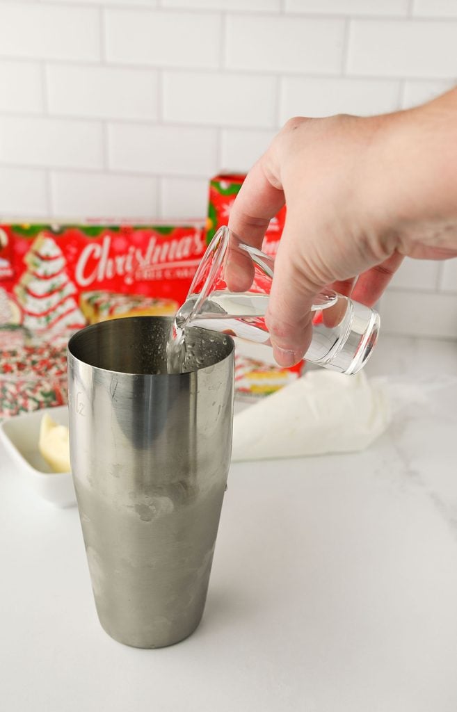Pouring vodka into the cocktail shaker.