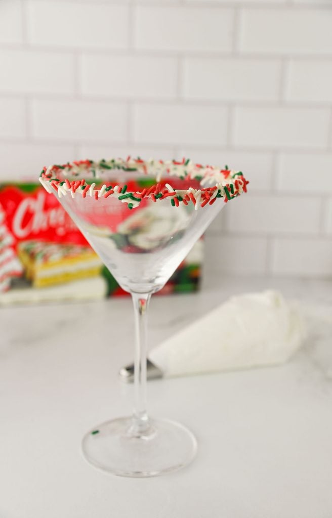 A martini glass with a red and green sprinkle rim.
