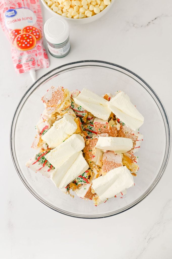 Crumbled Little Debbie Christmas Tree Cakes and cream cheese in a mixing bowl.