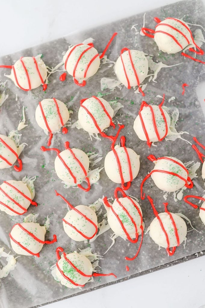 Red cookie icing piped over white chocolate truffles to resemble Little Debbie Christmas Tree Cakes.