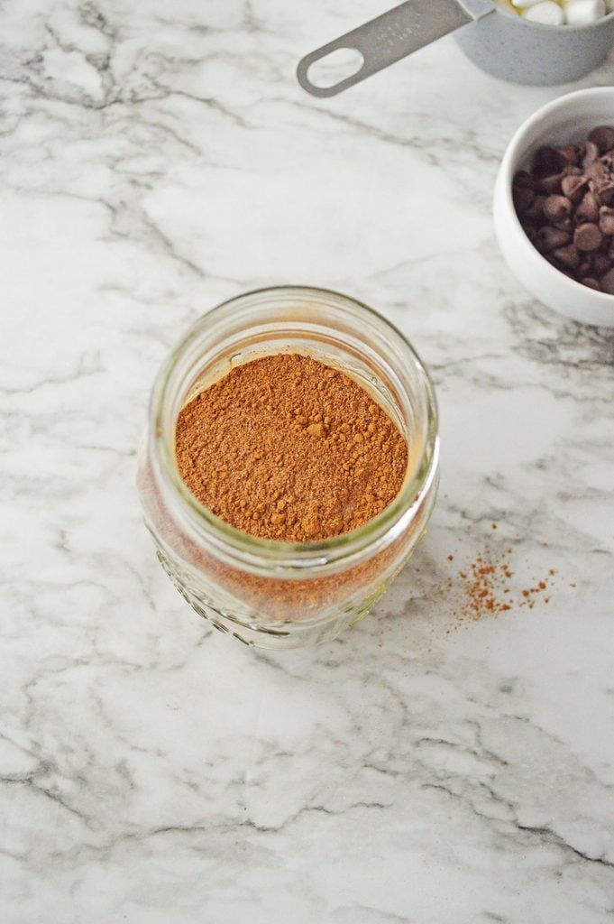 Homemade hot cocoa and sugar mixture added to a glass mason jar