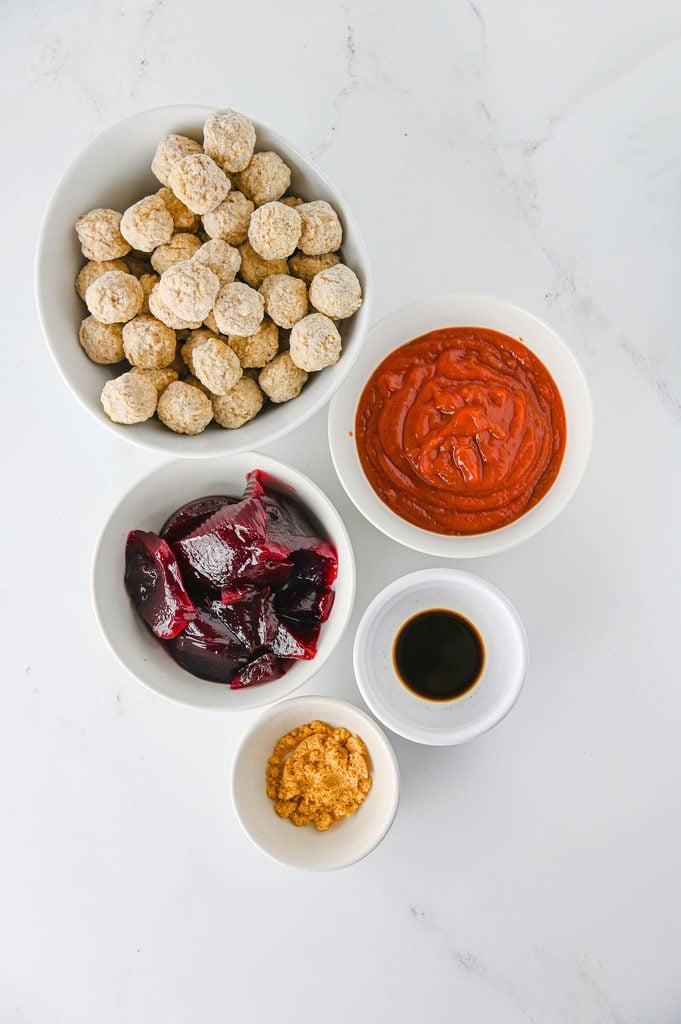 Ingredients for Crockpot cranberry meatballs including meatballs, chili sauce, jellied cranberry sauce, brown sugar, and Worcestershire sauce