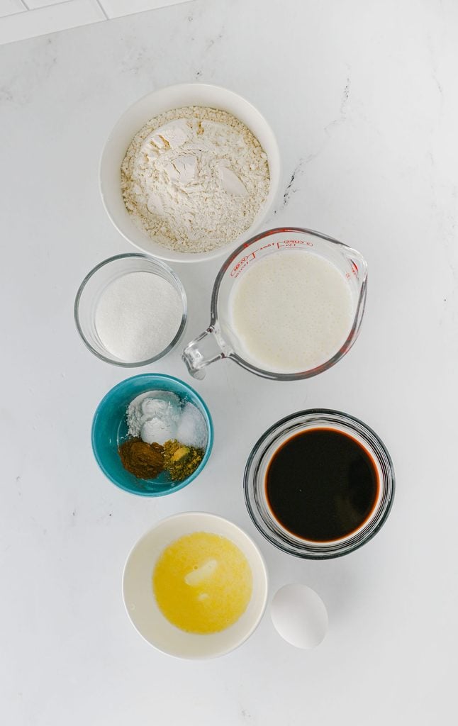 Ingredients for homemade gingerbread pancakes, including flour, buttermilk, molasses, and warm spices.