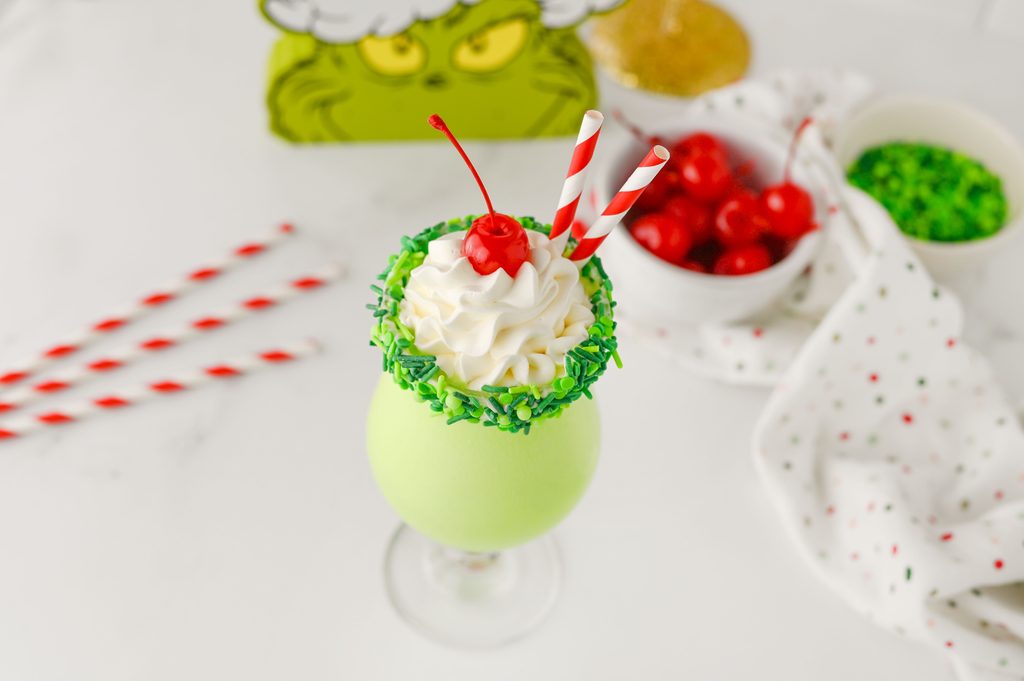 Green Christmas milkshakes topped with whipped cream and cherries