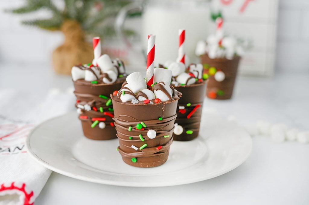 Close-up of a chocolate hot cocoa stick with mini marshmallows and a red paper straw