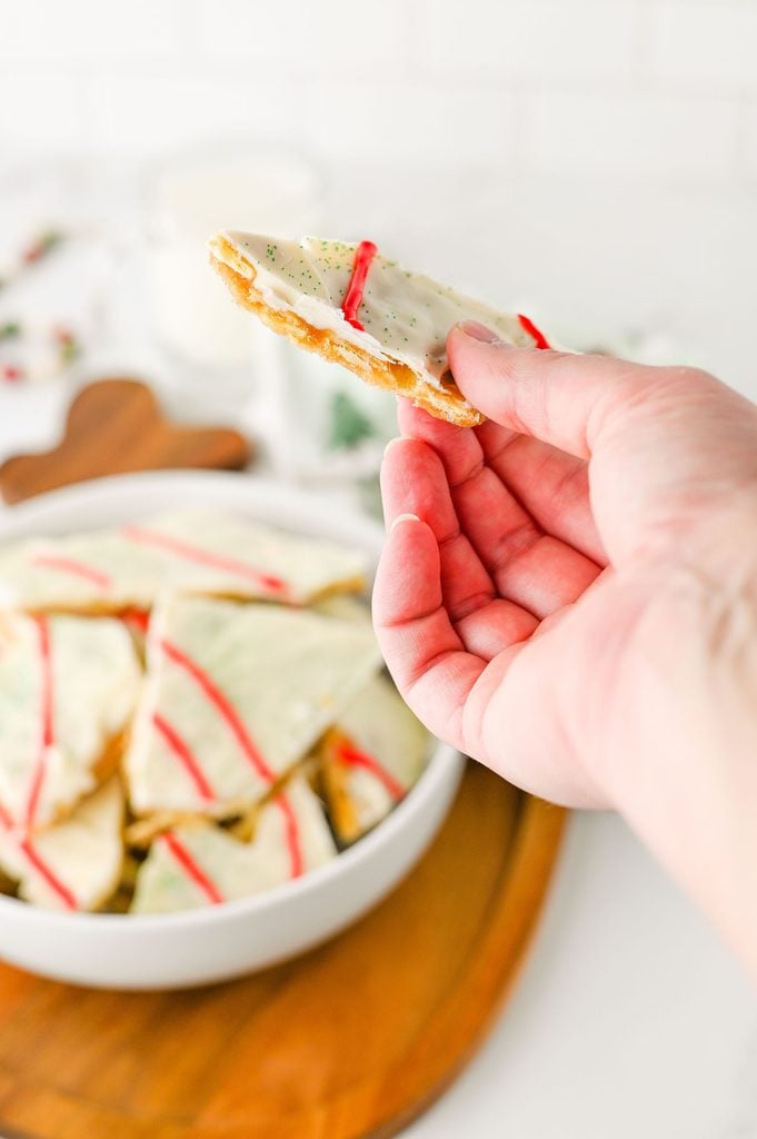 Close-up of white chocolate Christmas crack with red icing drizzle and green sugar sprinkles.