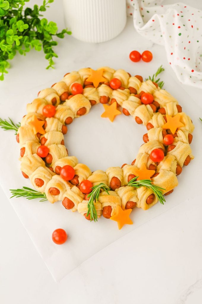 Festive pigs in a blanket Christmas wreath made with golden crescent rolls and little smokies.
