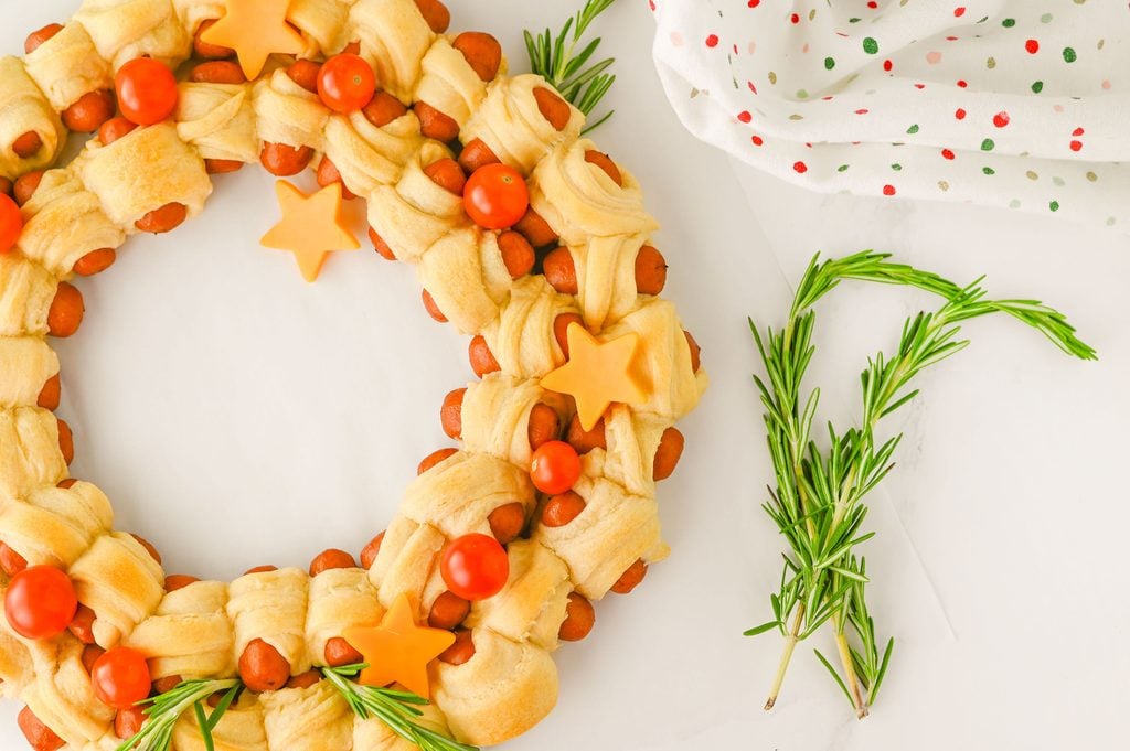 Christmas party appetizer featuring little smokies wrapped in crescent dough and arranged into an edible wreath.