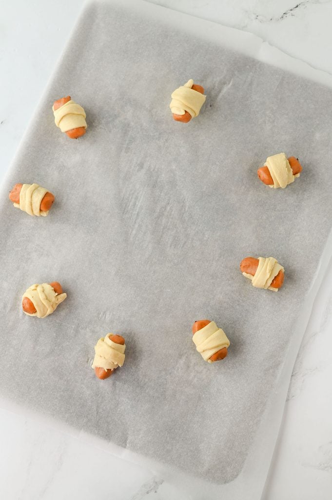 Little smokies wrapped in crescent roll dough before baking.