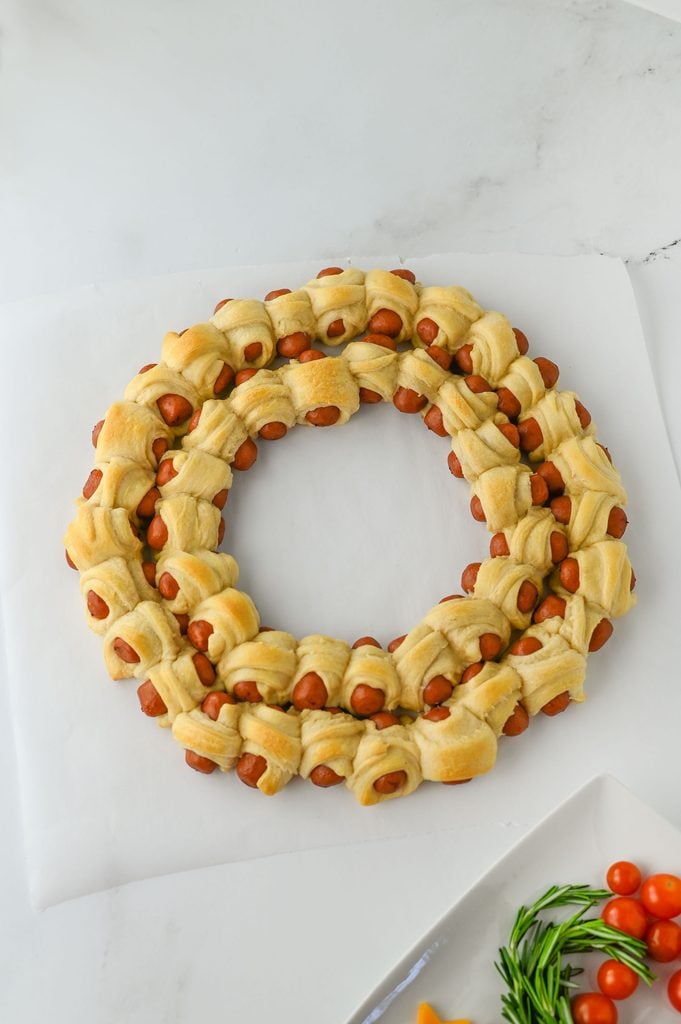 Freshly baked pigs in a blanket wreath with golden brown crescent roll dough.